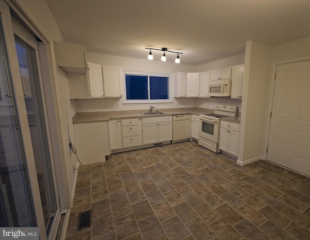 kitchen with white cabinetry, white appliances, and sink