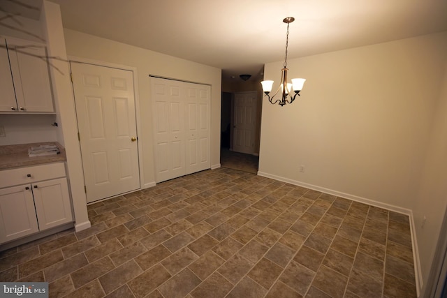 unfurnished dining area featuring a chandelier