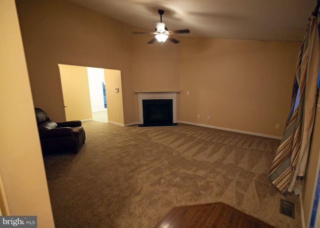 unfurnished living room featuring carpet, ceiling fan, and a towering ceiling