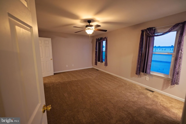 empty room featuring ceiling fan and carpet floors