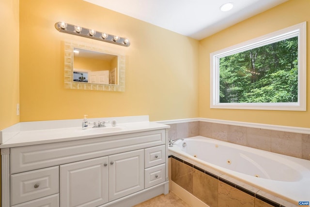 bathroom featuring a relaxing tiled tub and vanity