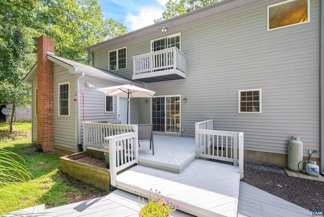 rear view of house with a wooden deck and a balcony