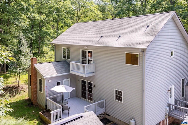 back of house with a balcony and a wooden deck