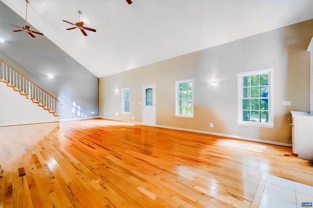 unfurnished living room featuring high vaulted ceiling and light hardwood / wood-style floors