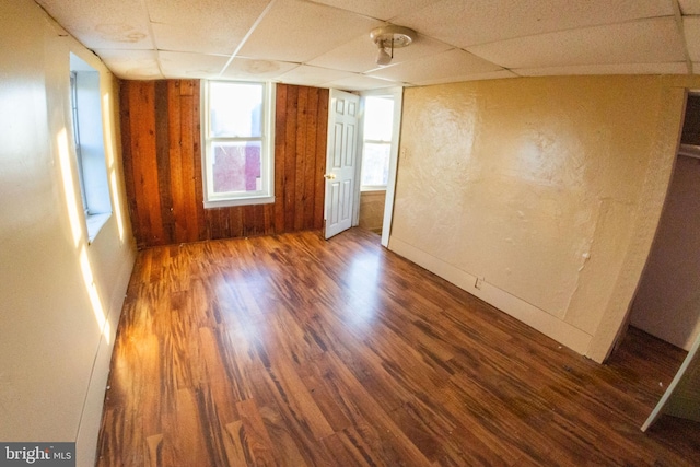 empty room with a drop ceiling and wood finished floors