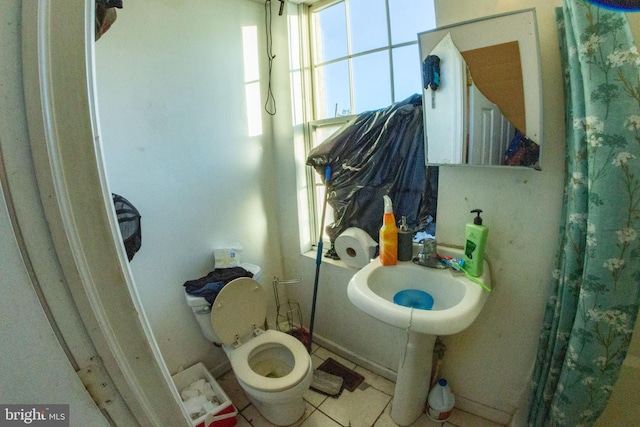 bathroom with a sink, toilet, and tile patterned floors