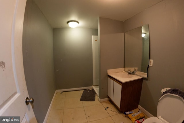 bathroom featuring baseboards, a shower stall, vanity, and tile patterned floors