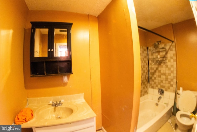 bathroom with toilet, vanity, shower / tub combination, and a textured ceiling