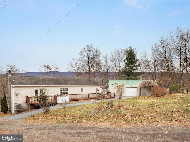 view of side of home featuring a wooden deck and a garage