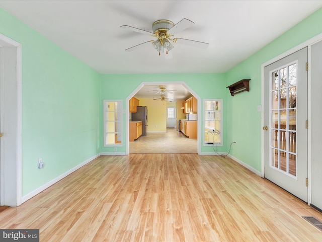 unfurnished living room featuring ceiling fan and light wood-type flooring