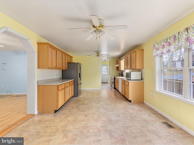 kitchen with light wood-type flooring, white appliances, and ceiling fan