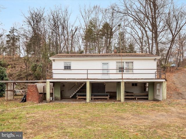 rear view of house with a lawn and a wooden deck