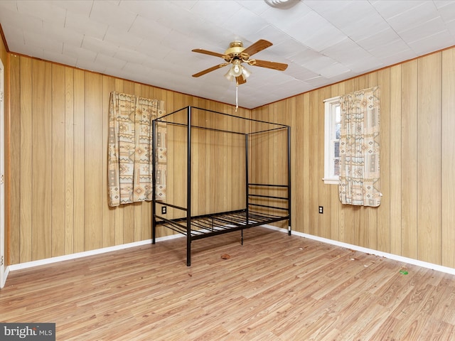 unfurnished bedroom featuring hardwood / wood-style flooring and wooden walls