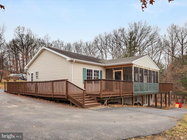 back of house with a sunroom and a deck