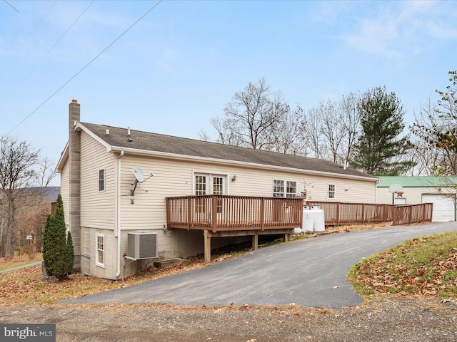 back of house featuring cooling unit and a wooden deck