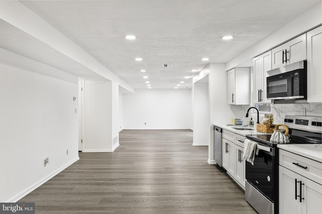 kitchen with dark wood-type flooring, sink, white cabinets, and stainless steel appliances