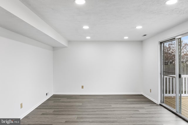 spare room featuring wood-type flooring and a textured ceiling