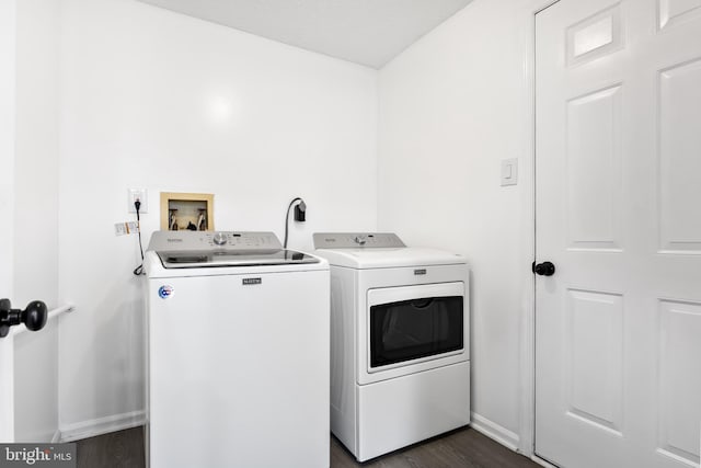 laundry area with separate washer and dryer and dark wood-type flooring