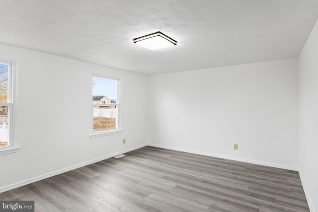 spare room with hardwood / wood-style floors and a textured ceiling