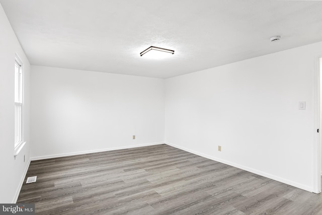 unfurnished room with a wealth of natural light and hardwood / wood-style floors