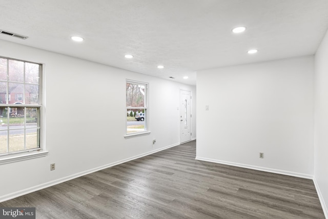 empty room featuring dark hardwood / wood-style floors and plenty of natural light