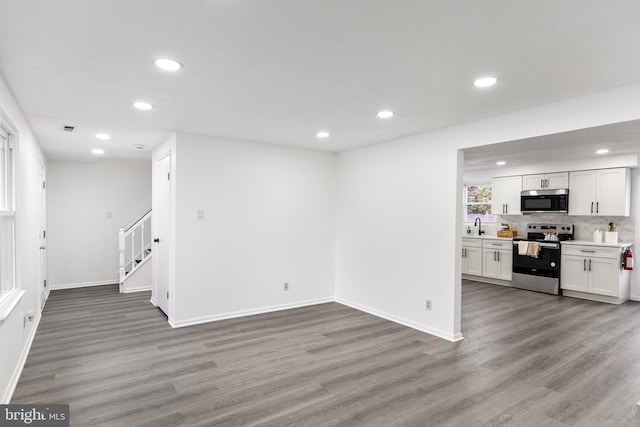 unfurnished living room featuring sink and light wood-type flooring