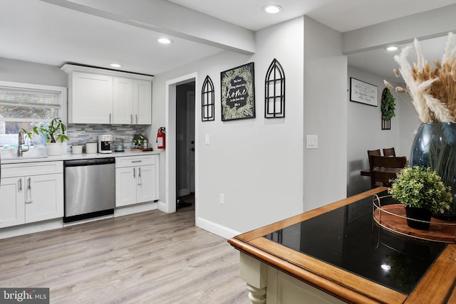 kitchen with white cabinetry, sink, stainless steel dishwasher, and light wood-type flooring