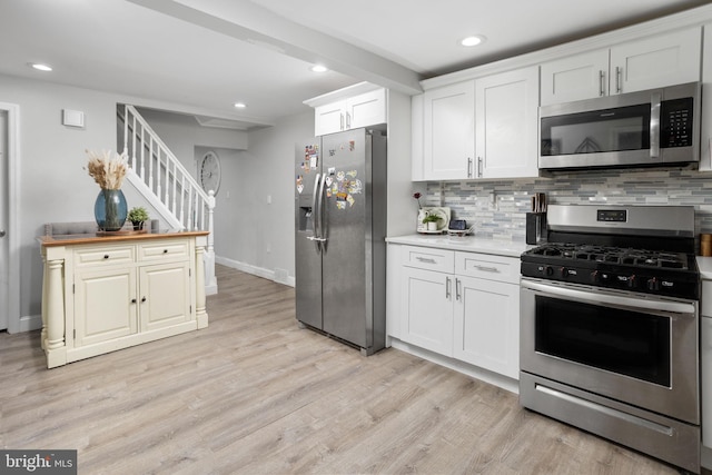 kitchen with stainless steel appliances, white cabinets, light wood-type flooring, and decorative backsplash