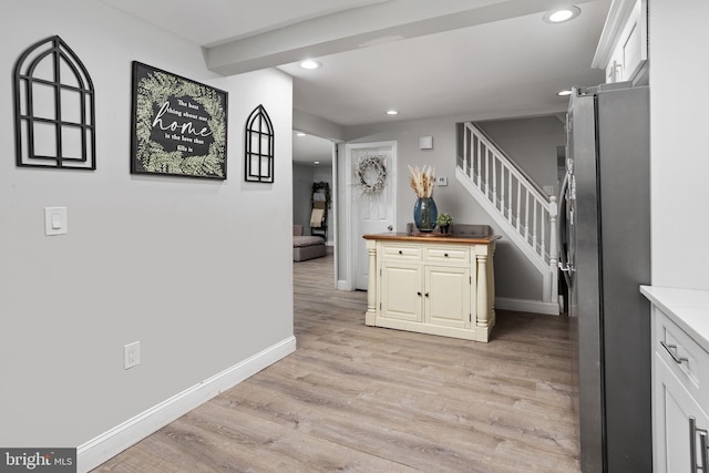 kitchen with white cabinetry, stainless steel fridge, butcher block countertops, and light hardwood / wood-style flooring