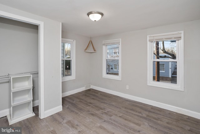 unfurnished bedroom featuring wood-type flooring and multiple windows