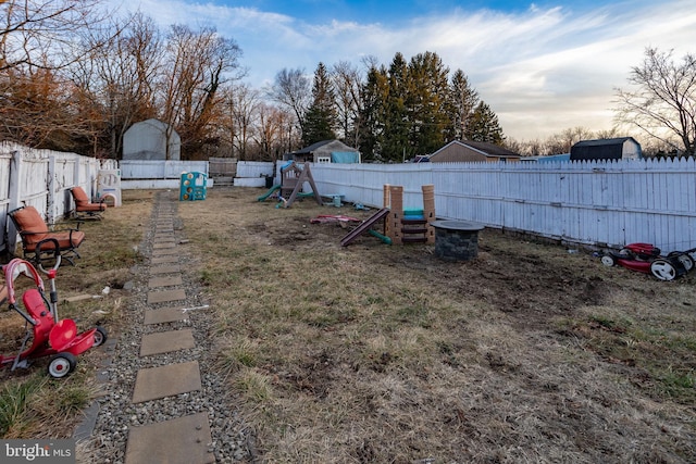 yard at dusk featuring a playground