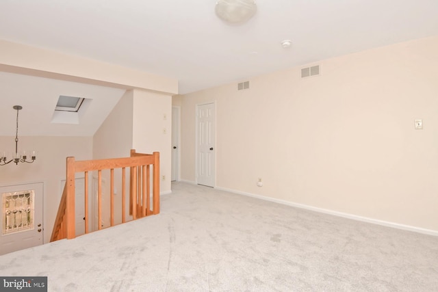 unfurnished room with a chandelier, light colored carpet, and vaulted ceiling