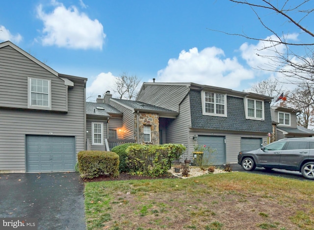 split level home featuring a garage and a front lawn