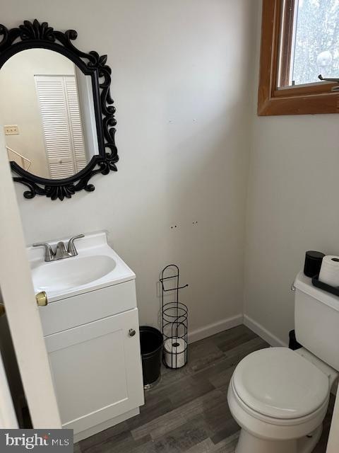 bathroom with wood-type flooring, vanity, and toilet