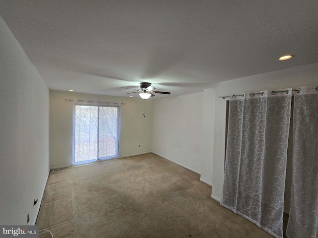 carpeted spare room with a textured ceiling and ceiling fan