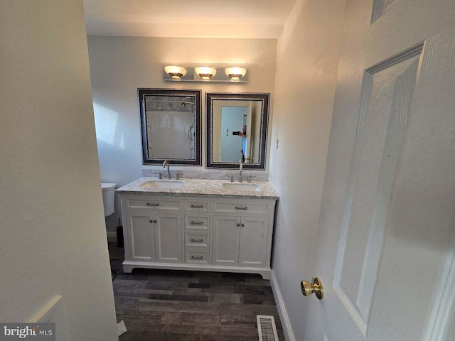 bathroom featuring wood-type flooring, vanity, and toilet