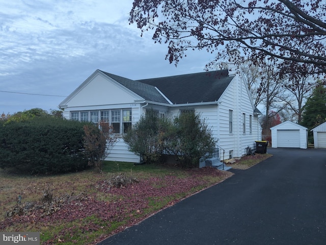 view of front facade featuring a garage and an outbuilding