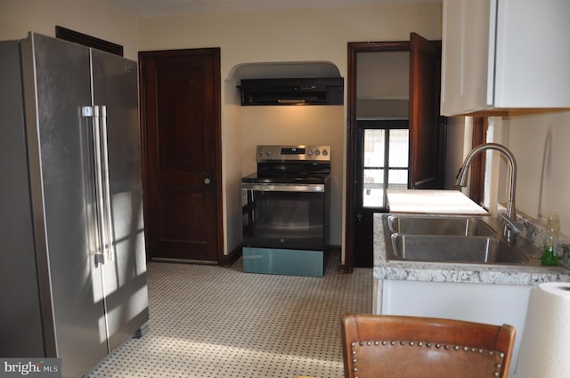 kitchen with appliances with stainless steel finishes, dark brown cabinetry, ventilation hood, sink, and white cabinetry