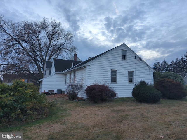 view of side of home with a yard