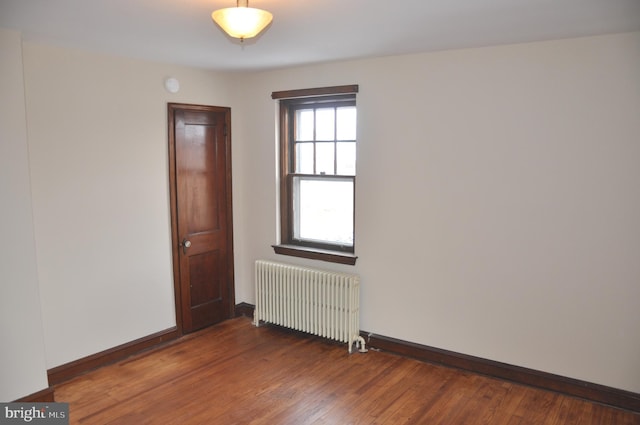 empty room with radiator and dark hardwood / wood-style floors