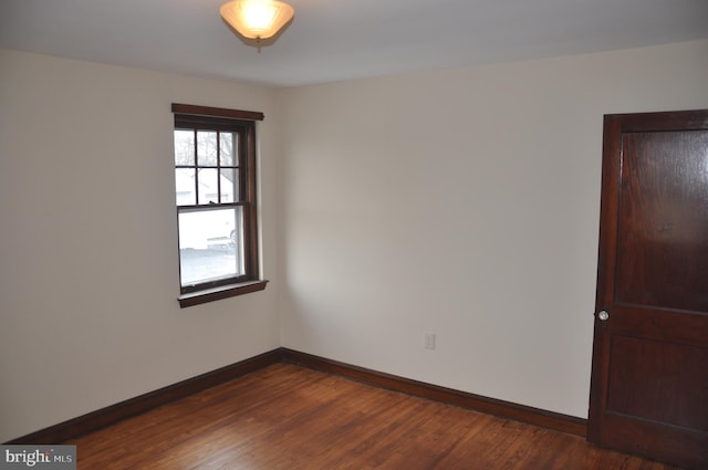 unfurnished room with dark wood-type flooring