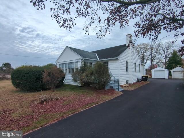 view of side of property with an outdoor structure and a garage