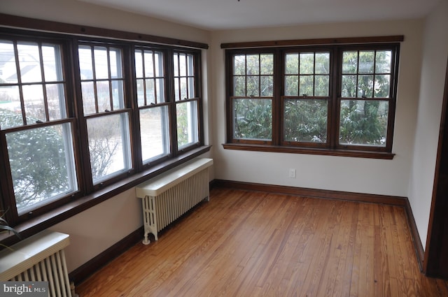 unfurnished sunroom with radiator and a wealth of natural light