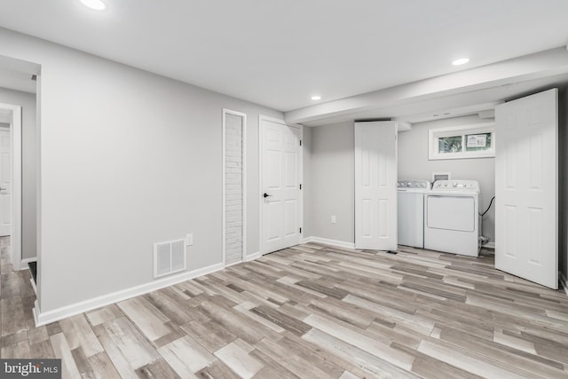 washroom featuring washing machine and dryer and light hardwood / wood-style floors