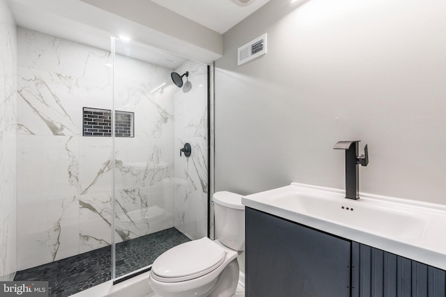 bathroom featuring tiled shower, vanity, and toilet