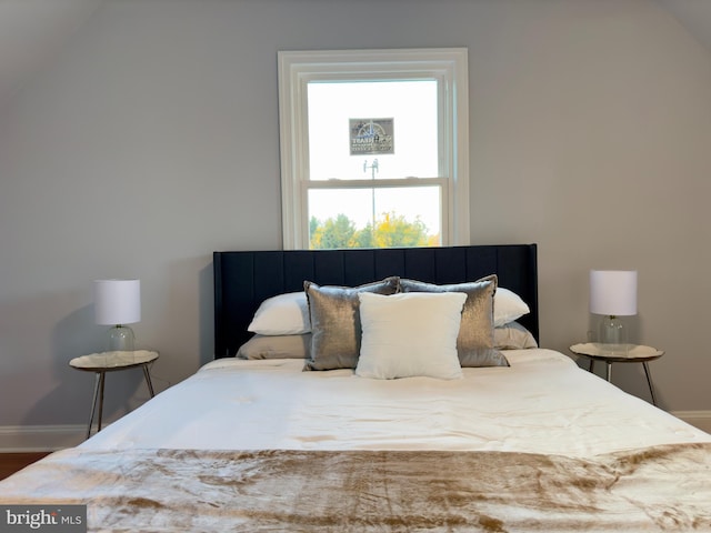 bedroom with hardwood / wood-style floors and vaulted ceiling