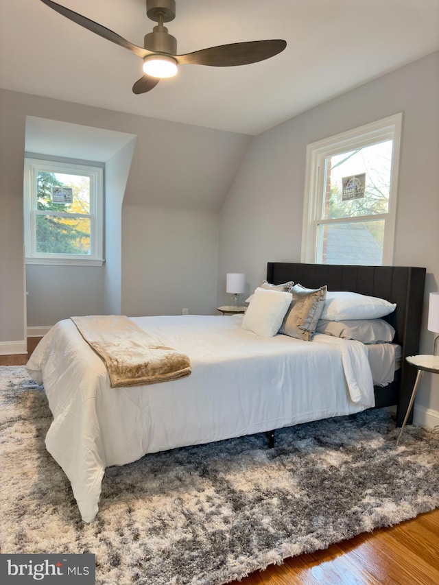 bedroom with hardwood / wood-style flooring, ceiling fan, and vaulted ceiling