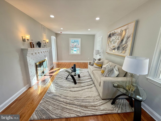 living room featuring hardwood / wood-style floors and a brick fireplace