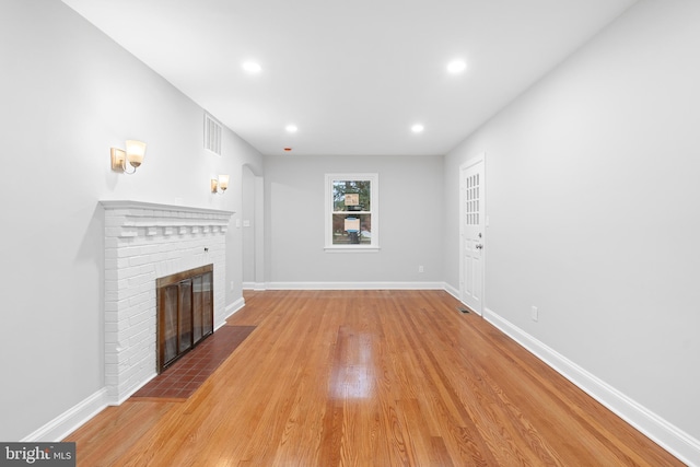 unfurnished living room featuring a fireplace and light hardwood / wood-style flooring