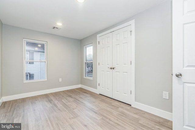 unfurnished bedroom featuring a closet and light hardwood / wood-style flooring